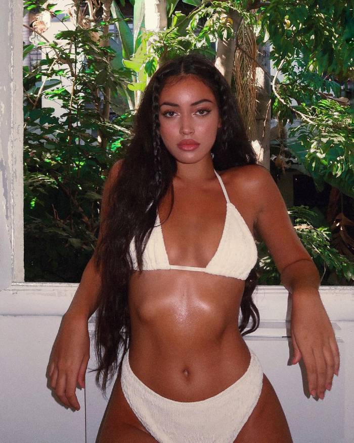 Cindy Kimberly looking exotic in a white bikini in front of a window