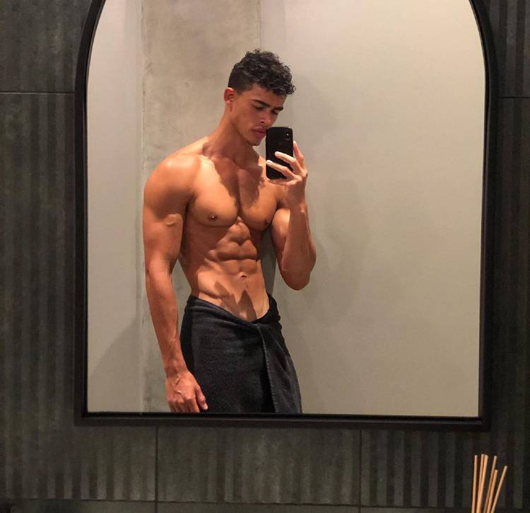 Devin Truss taking a shirtless mirror selfie, looking muscular and ripped