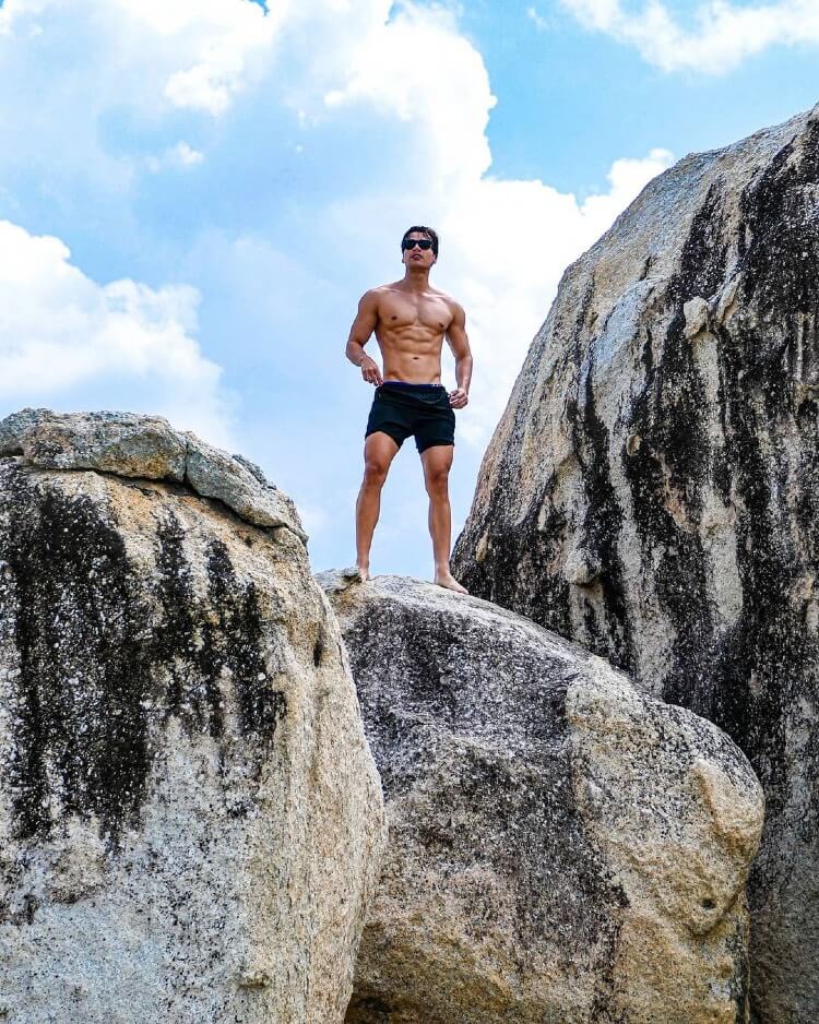 Hans Weiser posing shirtless on massive rocks